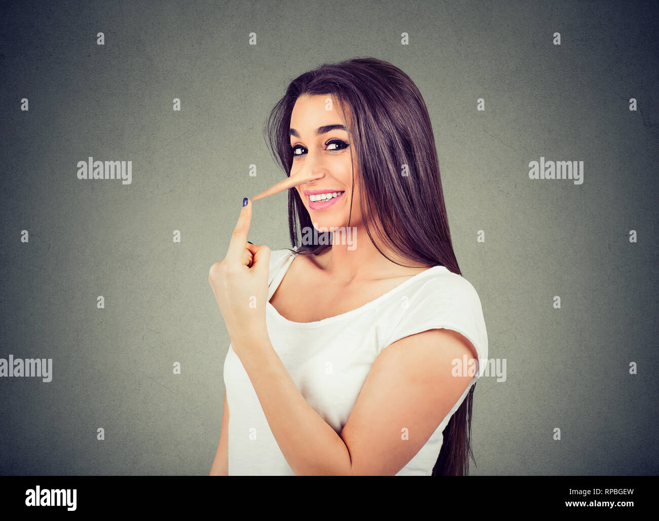 Happy Lügner Frau mit langer Nase auf grauem Hintergrund. Menschliche Emotionen, Gefühle. Stockfoto