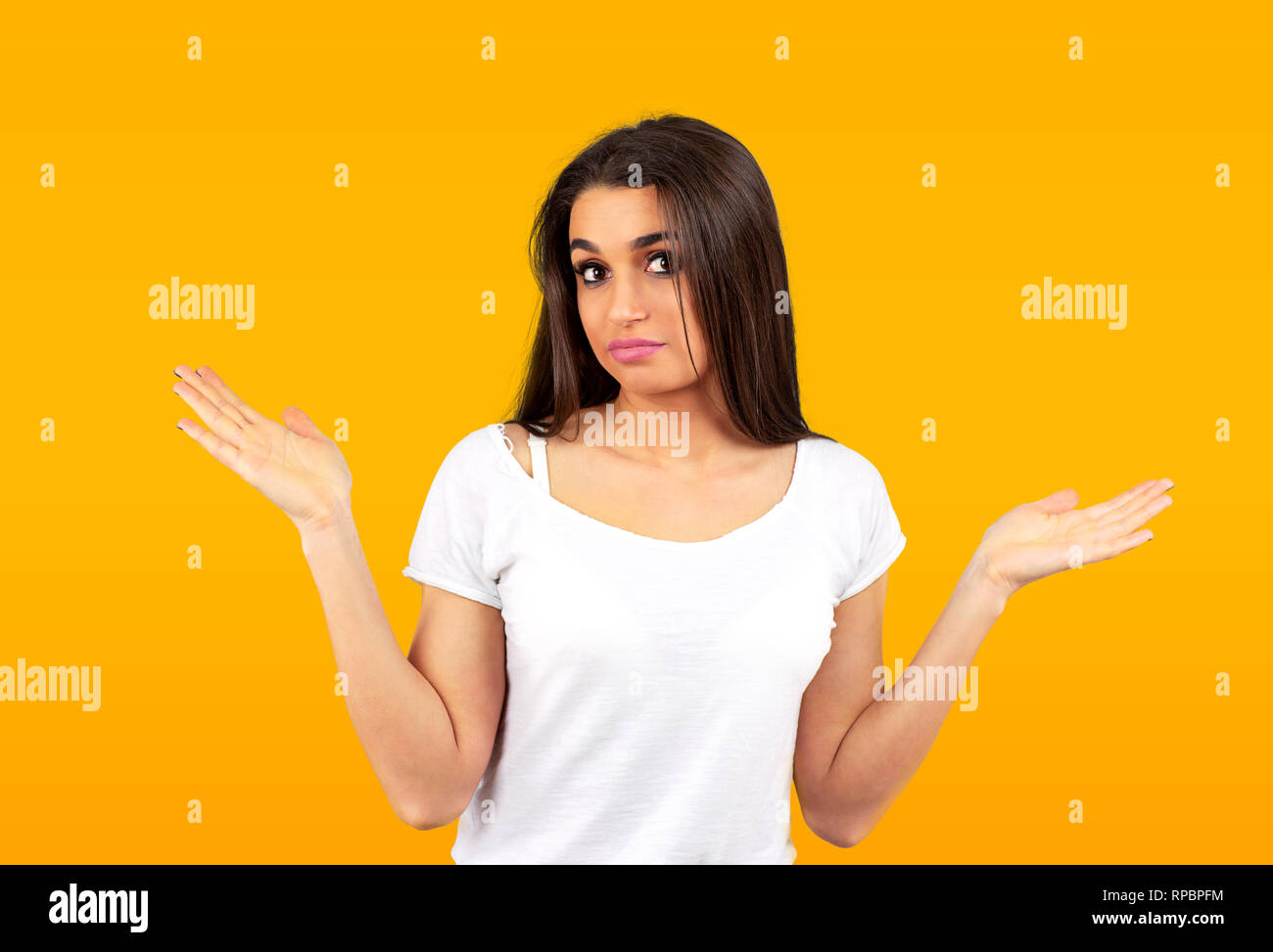Porträt eines verwirrten jungen Casual Mädchen Achselzucken auf gelbem Hintergrund Stockfoto
