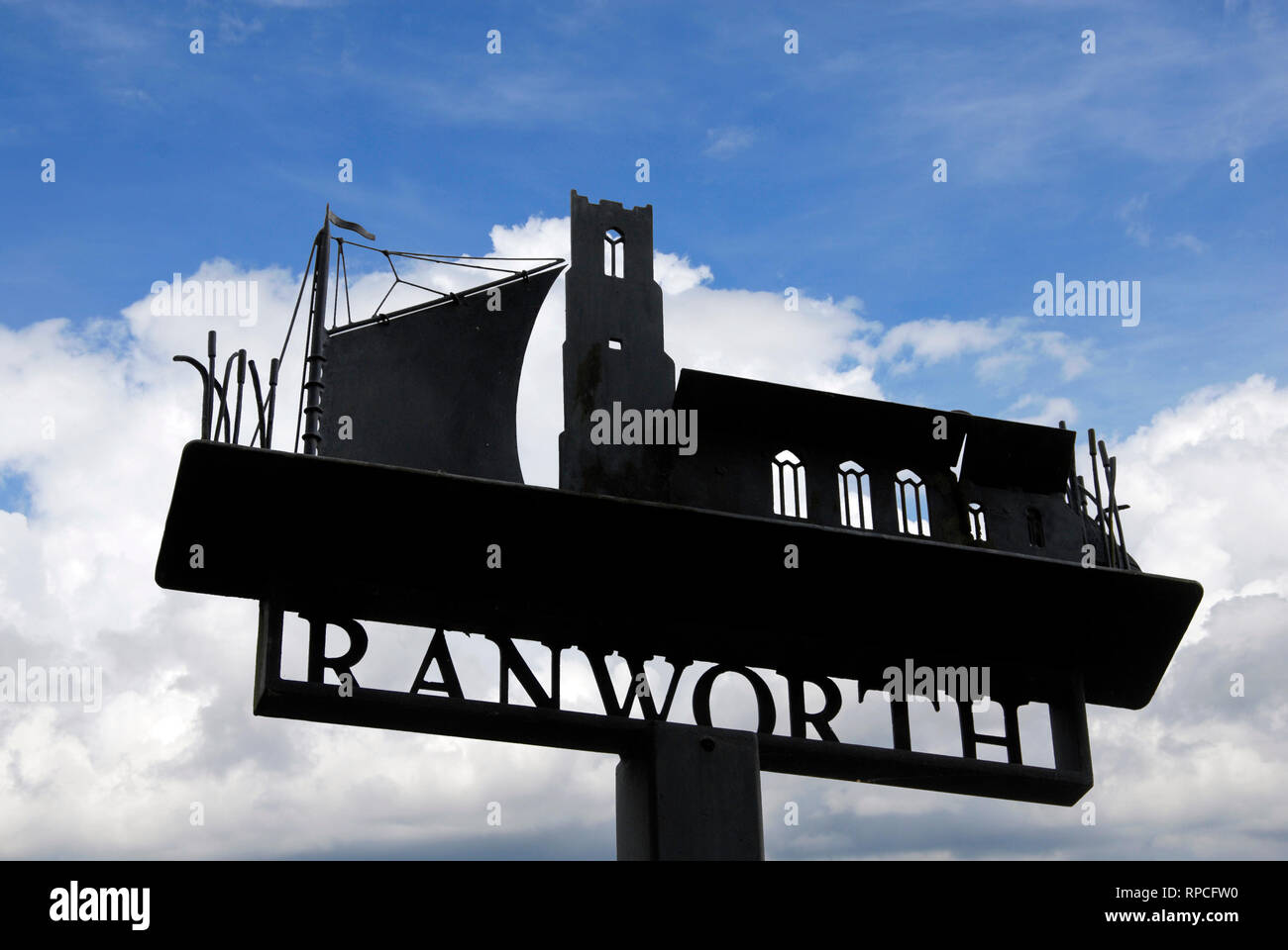 Dorf Schild "Ranworth' gegen den blauen Himmel an der Oberseite und an der sonnigen weißen Wolken unter Silhouette Stockfoto