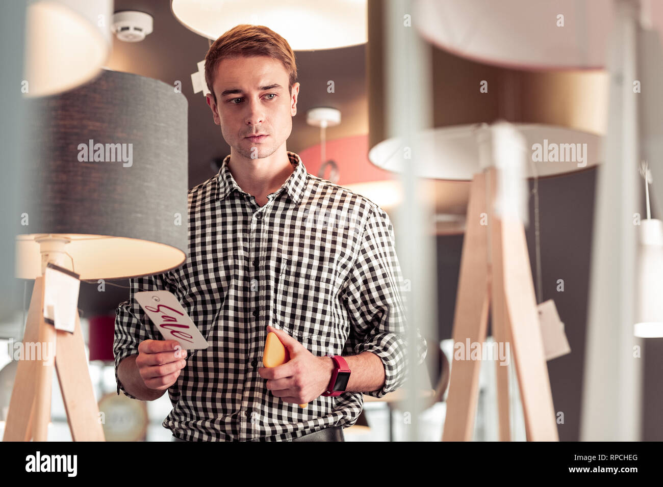 Portrait von nachdenklich konzentriert nach Gentleman holding Telefon im Showroom Stockfoto