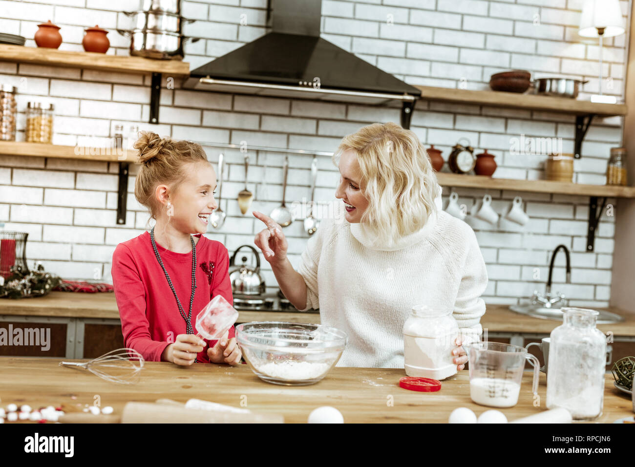 Fröhliche blonde gutaussehende Dame zeigt auf schmutzigen Nase Stockfoto