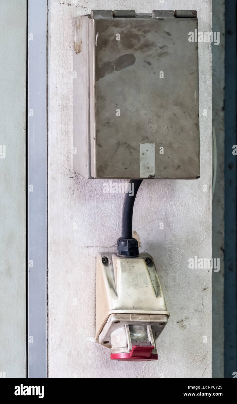 Die Steckdose mit dem Metall Box auf dem Zement Wand für den Einsatz in der alten Fabrik. Stockfoto