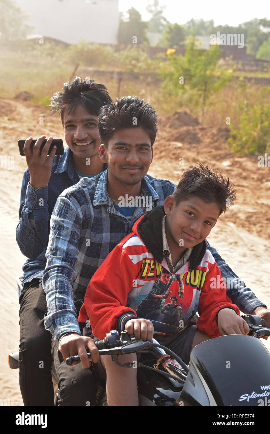 Drei junge Männer posieren für die Kamera auf einem Motorrad, nur etwas außerhalb des beeindruckenden Ranthambhore Nationalpark, Rajasthan, Indien, Asien. Stockfoto