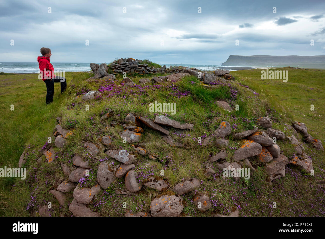 Person neben den Ruinen einer alten Fischersiedlung an Brunnar. Latrabjarg Halbinsel, Westfjorde, Island. Stockfoto