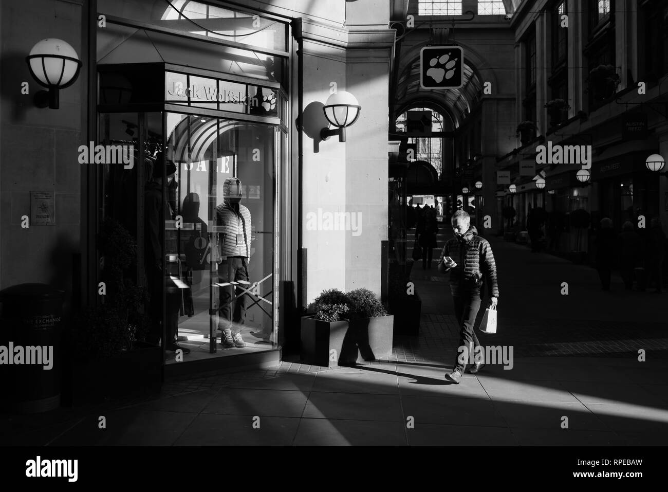 Man Walking Vergangenheit Retail Stores in städtische Umwelt. Stockfoto