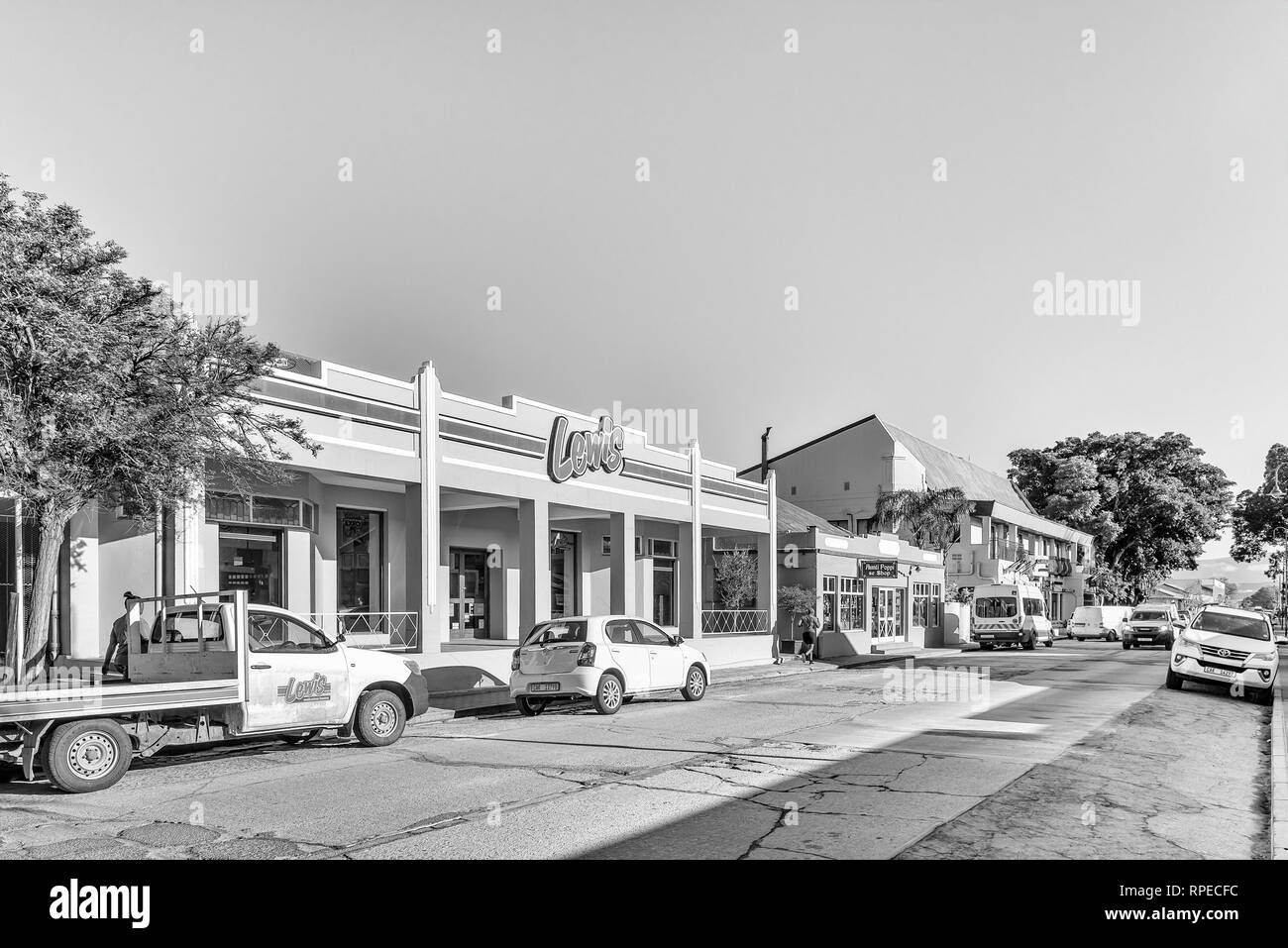 CLANWILLIAM, SÜDAFRIKA, 28. AUGUST 2018: eine Straße, Szene, mit Unternehmen, Fahrzeuge und Personen, in Clanwilliam in der Western Cape Provinz. Monochr Stockfoto