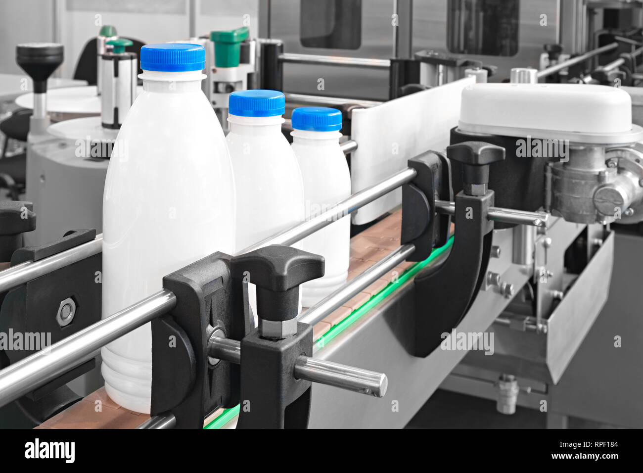 Plastikflaschen auf Transportband bereit für das Gießen von Milch Stockfoto