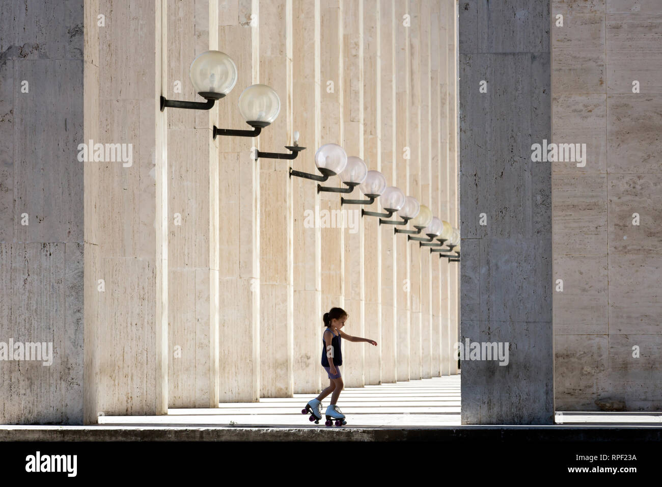 Rom - ein Mädchen auf rollerskates vor einem neoklassizistischen Gebäude in der Euro Zone. Stockfoto