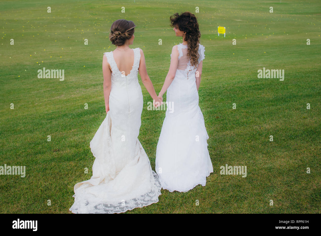 Zwei schöne Bräute, Hände auf den grünen Bereich des Golf Club Stockfoto