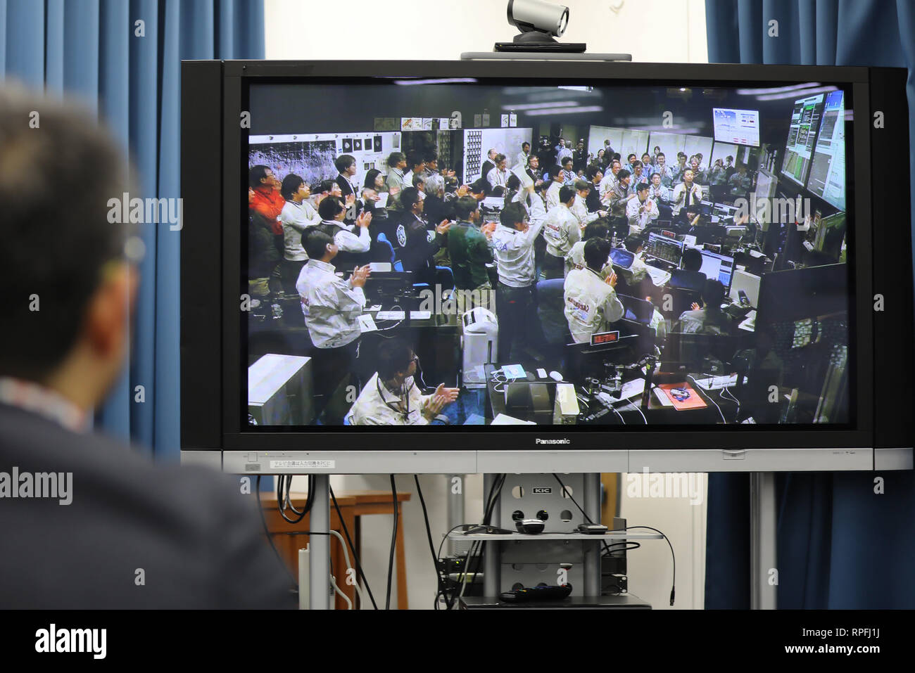 Tokio, Japan. 22 Feb, 2019. Ein Mann Uhren live Video bei der Japan Aerospace Exploration Agency (JAXA) Büro in Tokio, Japan, Jan. 22, 2019. Das Video zeigt die Mitarbeiter in der Leitstelle Jubel nach Daten zeigt, dass Hayabusa 2 erfolgreich auf dem Asteroiden Ryugu gelandet. Die japanische Raumsonde Hayabusa 2 erfolgreich gelandet auf dem Asteroiden Ryugu, Daten aus der JAXA Freitag bestätigt. Credit: Du Xiaoyi/Xinhua/Alamy leben Nachrichten Stockfoto