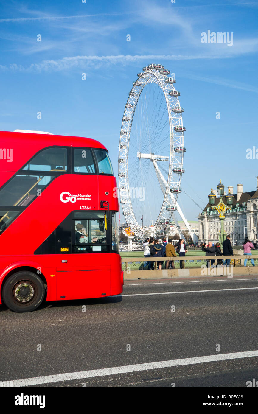 Red London Doppeldeckerbus über die Westminster Bridge mit dem London Eye im Hintergrund und blauen Himmel Himmel Stockfoto