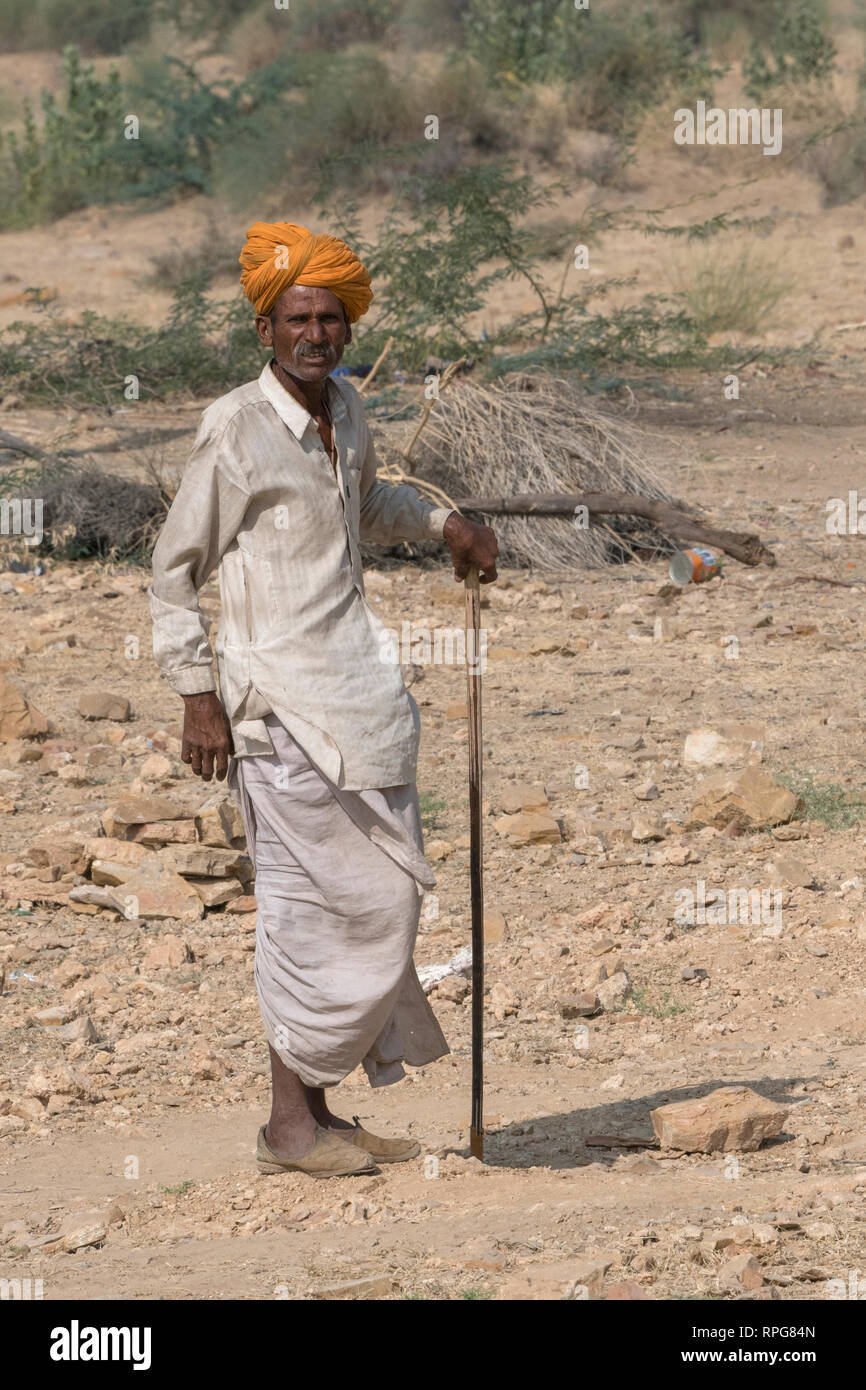 Native Mann mit Stock in Wüste, Jaisalmer, Rajasthan, Indien Stockfoto