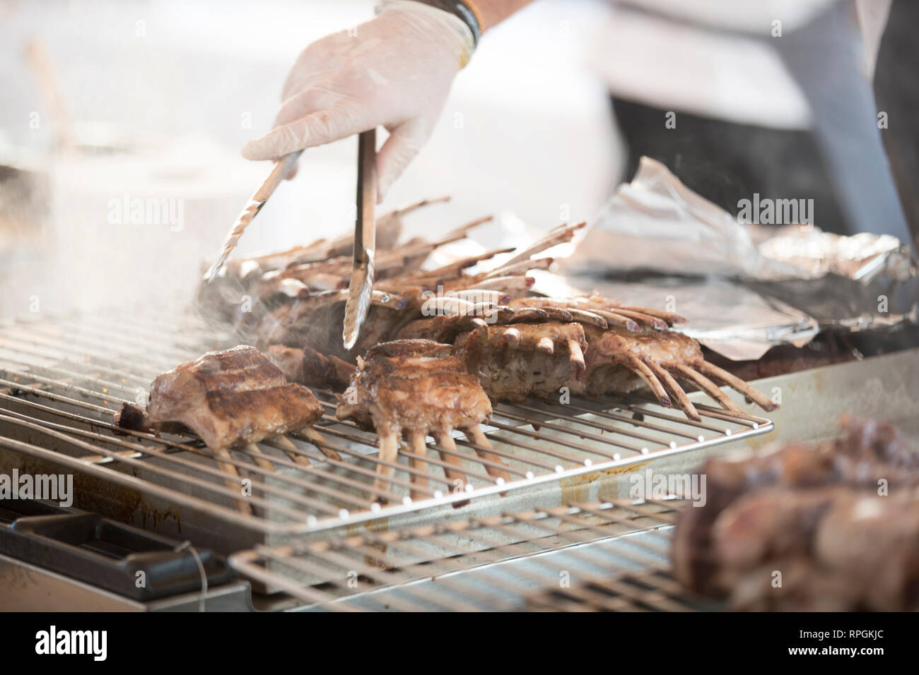 Nahaufnahme von einem Koch Kochen eine Menge Rindfleisch Steaks auf dem Grill Stockfoto