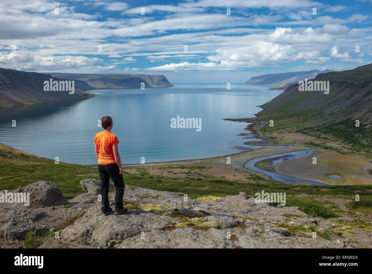 Person mit Blick über Arnarfjordur Fjord aus Nordfjall. Westfjorde, Island. Stockfoto