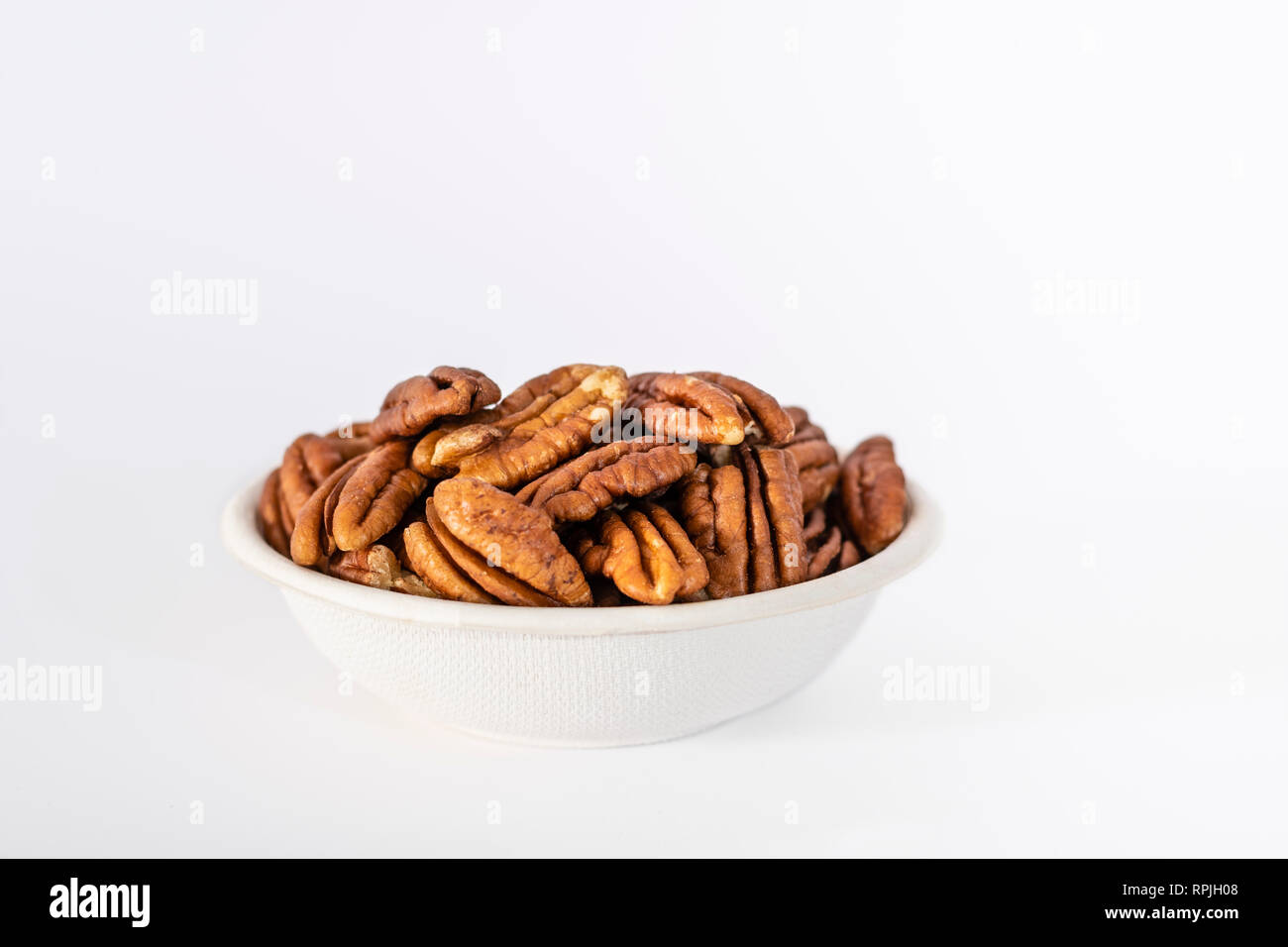 Schüssel mit Pekannuss (Carya illinoinensis) auf weißem Hintergrund Stockfoto