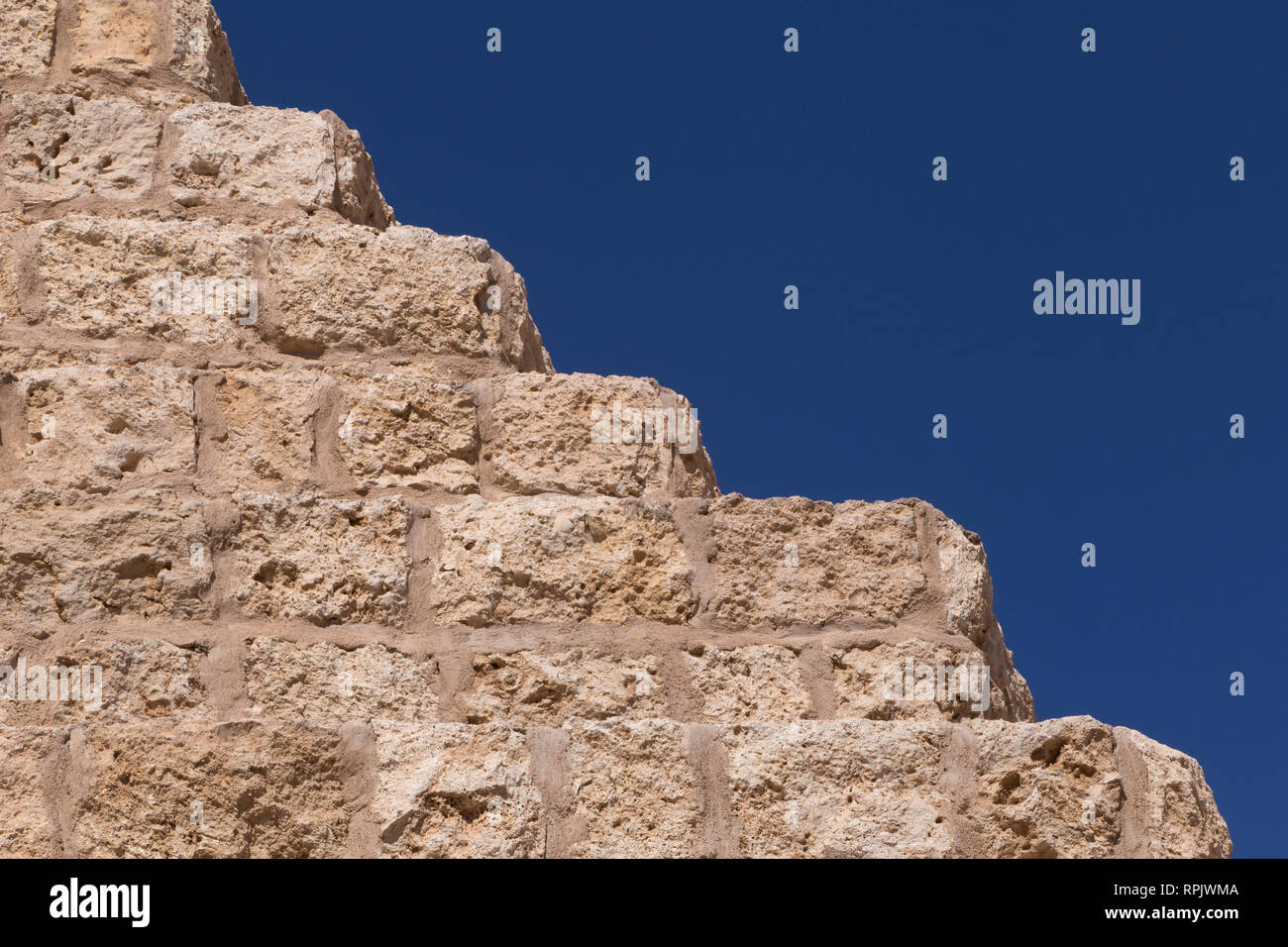 Steinmauer mit Schritte gegen den blauen Himmel Stockfoto