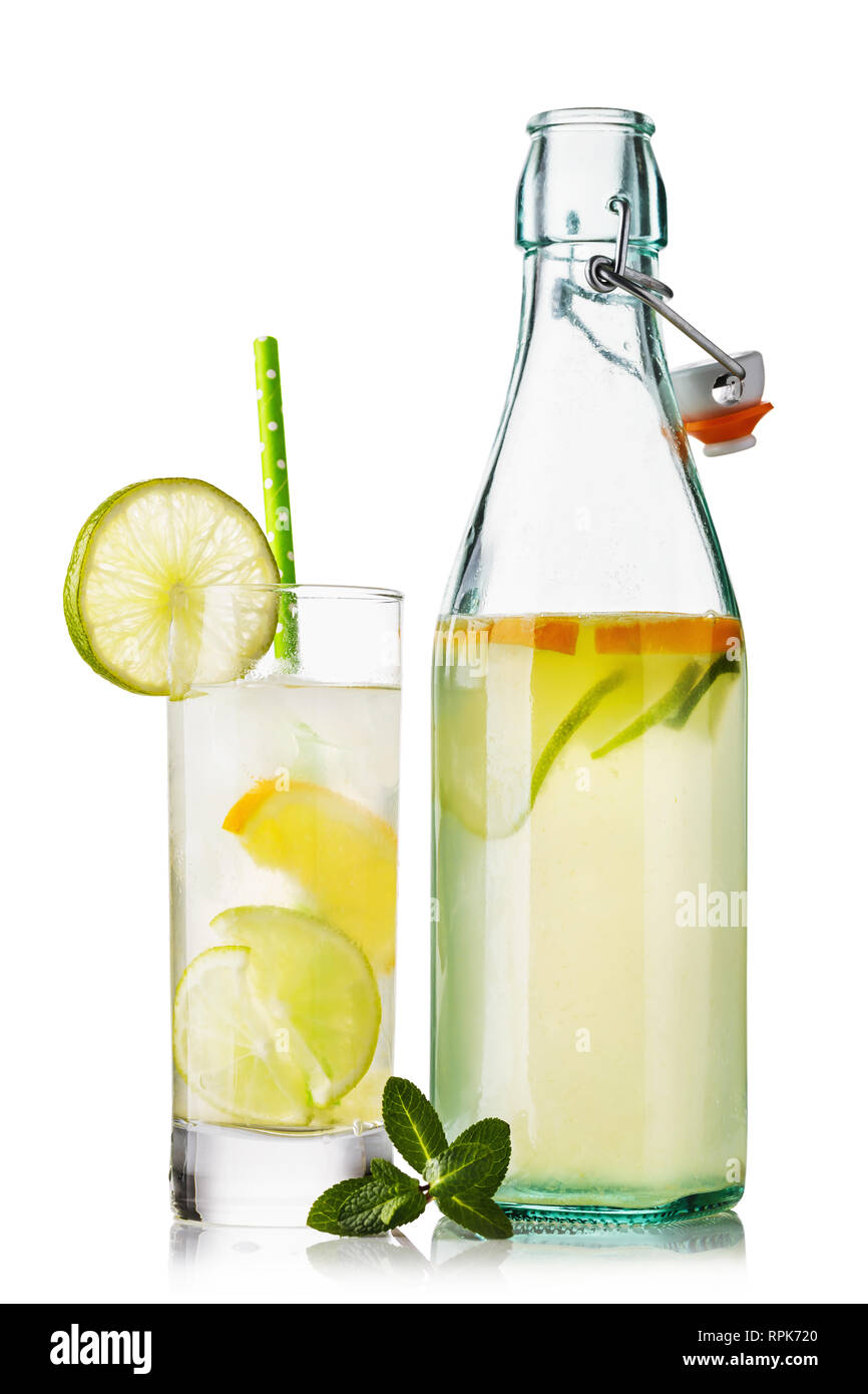 Wasser mit Zitrone und Limette in ein Glas und eine offene Flasche auf weißem Hintergrund Stockfoto
