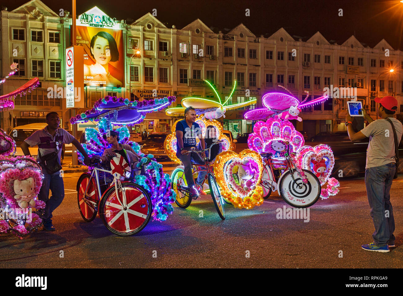 Die bunten Trishaws, eine Form der Fahrrad-powered Rikscha, dass Cruise in der Nacht in der Stadt von Malakka Stadt Stockfoto