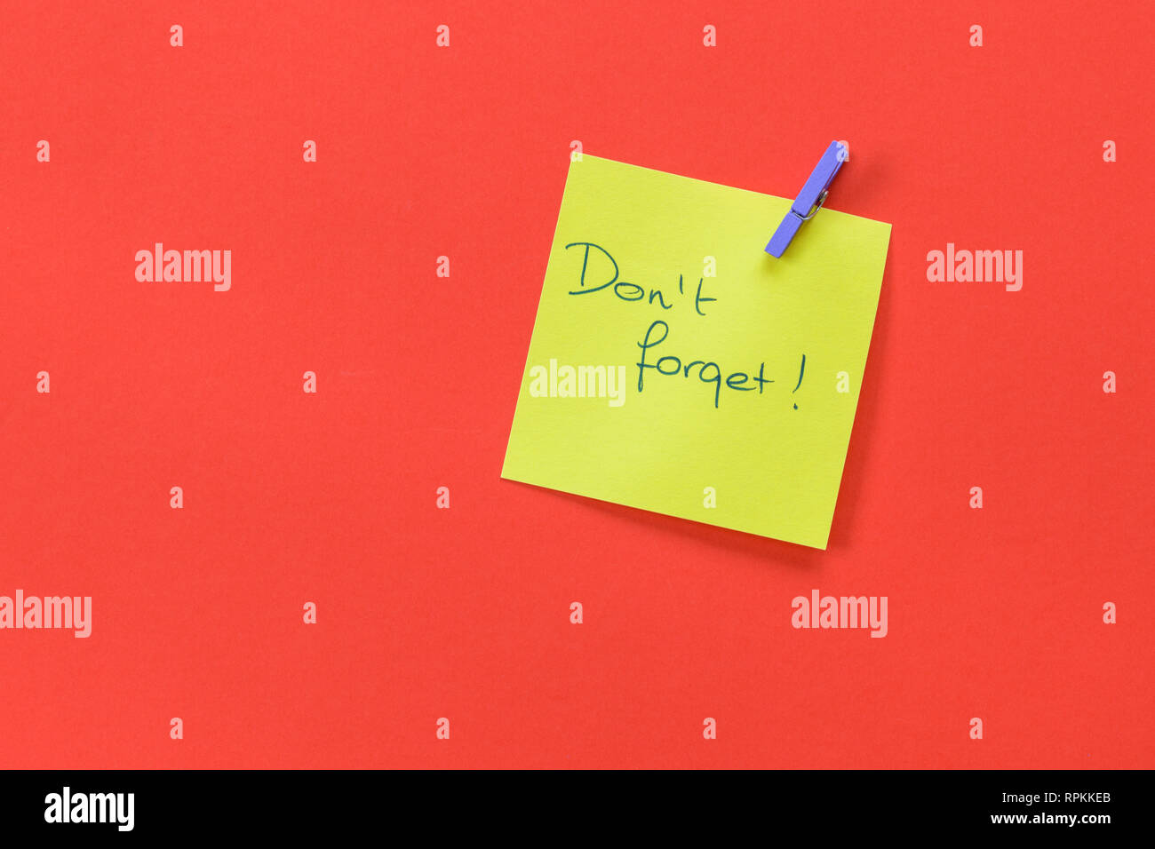 Erinnerung mit dem Text 'nicht vergessen' auf einem gelben Memo auf rotem Hintergrund Stockfoto
