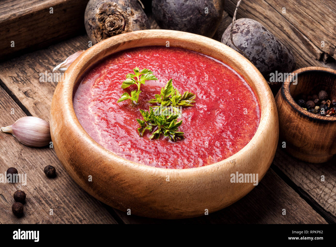 Rote-bete-Suppe und frisches Gemüse auf einem hölzernen Hintergrund Stockfoto