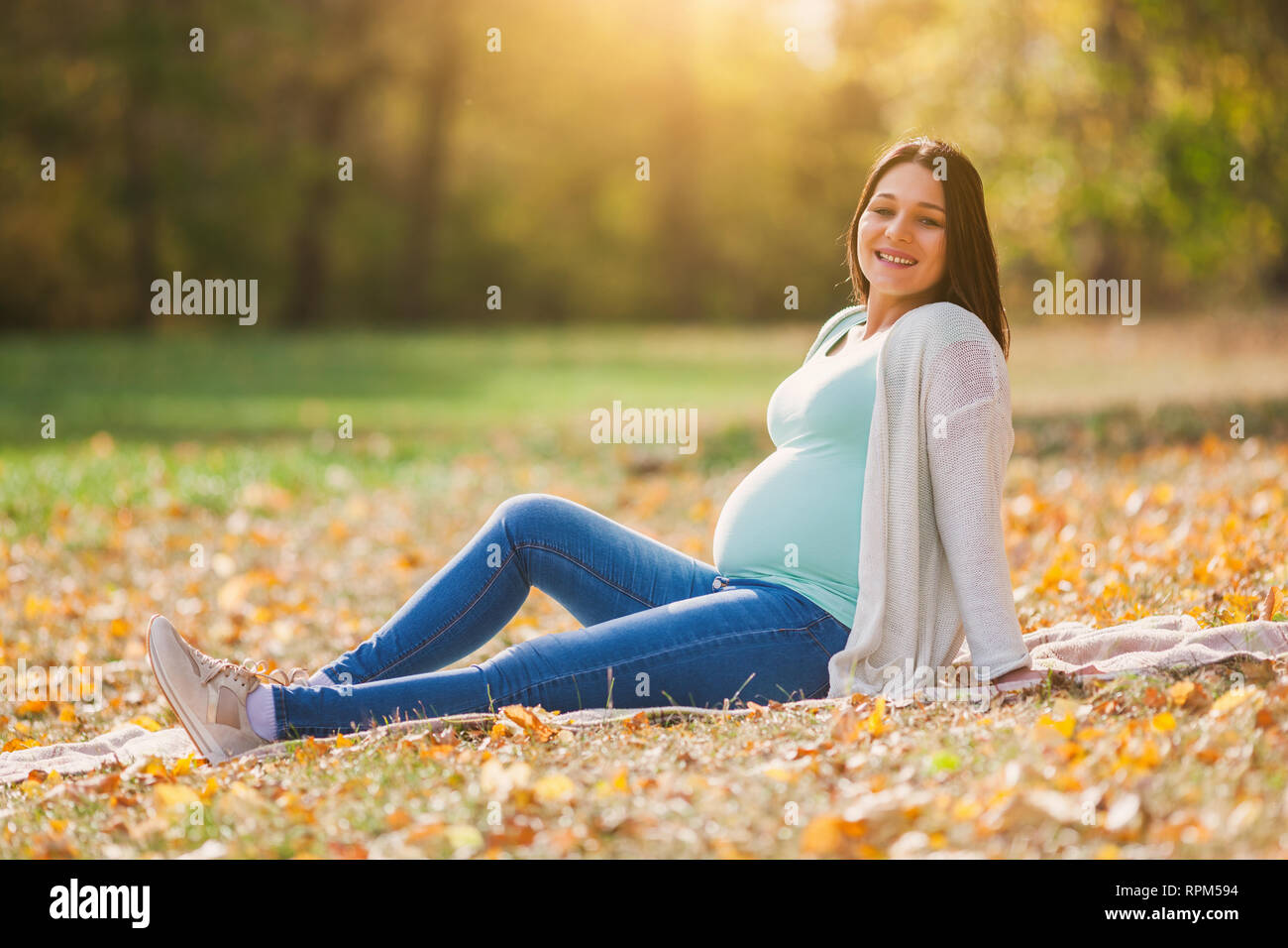 Gerne schwangere Frau im Park. Stockfoto
