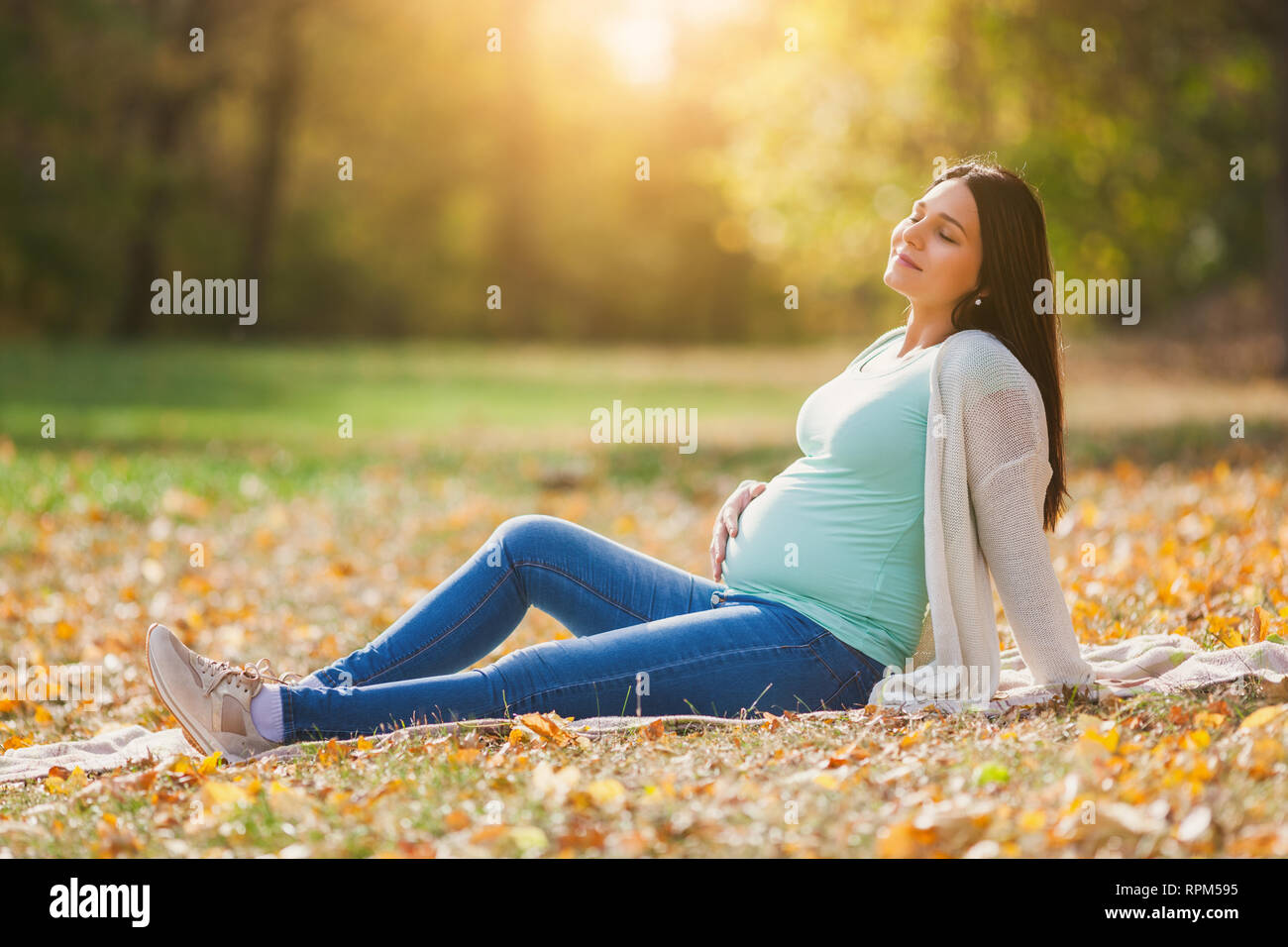 Gerne schwangere Frau im Park. Stockfoto