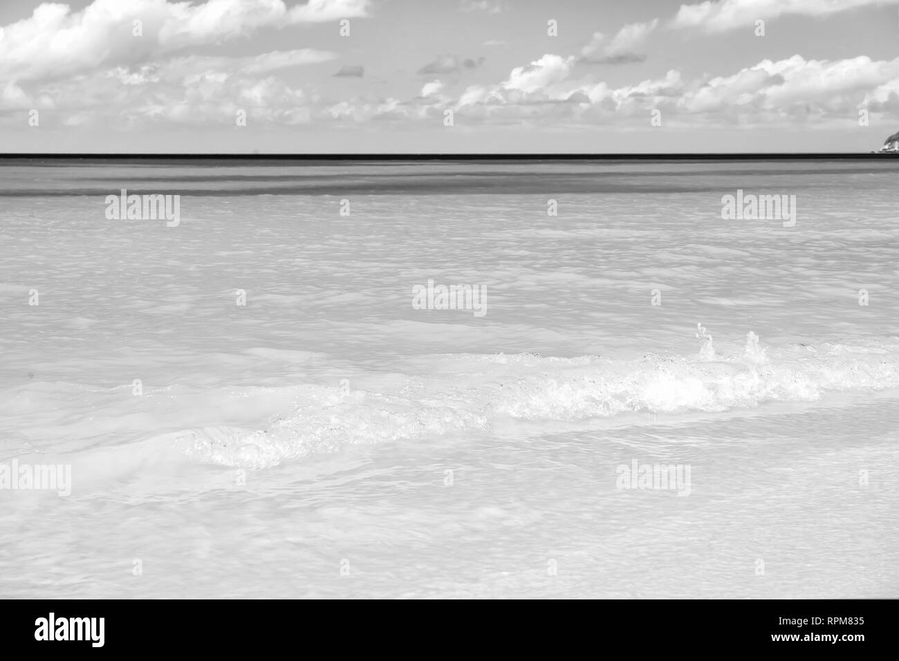 Meer oder Ozean Strand mit weissem Sand, türkisfarbenes Wasser Wellen in St. Johns, Antigua. An einem sonnigen Tag Seascape an bewölkten und blauer Himmel. Sommer, Urlaub, Natur, Schönheit, Paradies, Freiheit Konzept. Stockfoto