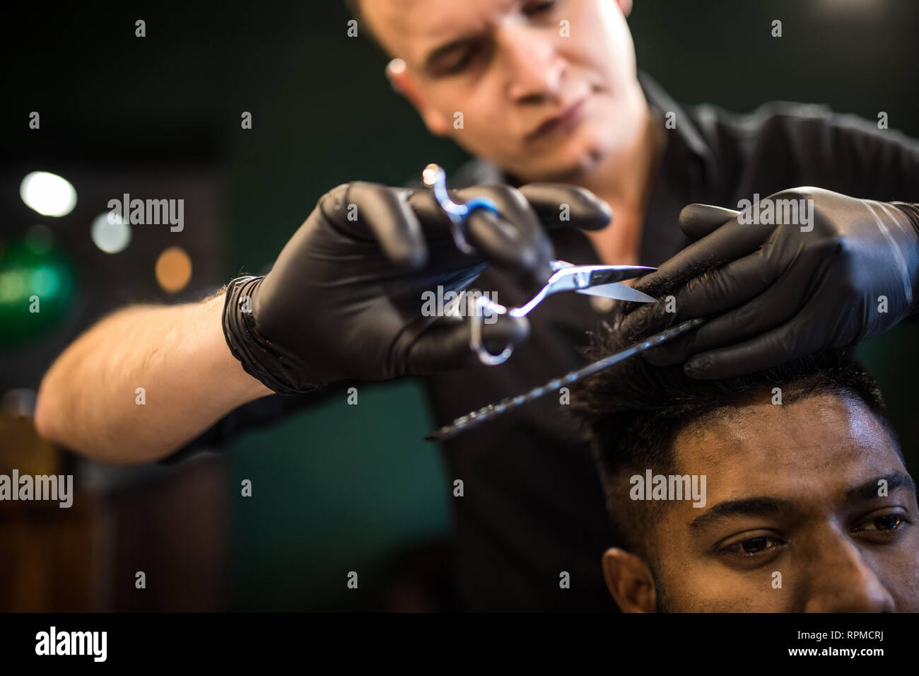 Nahaufnahme des Menschen immer trendy Haarschnitt beim Friseur. Männliche hairstylist Client dienen, Haarschnitt mit Maschine und Kamm. Stockfoto
