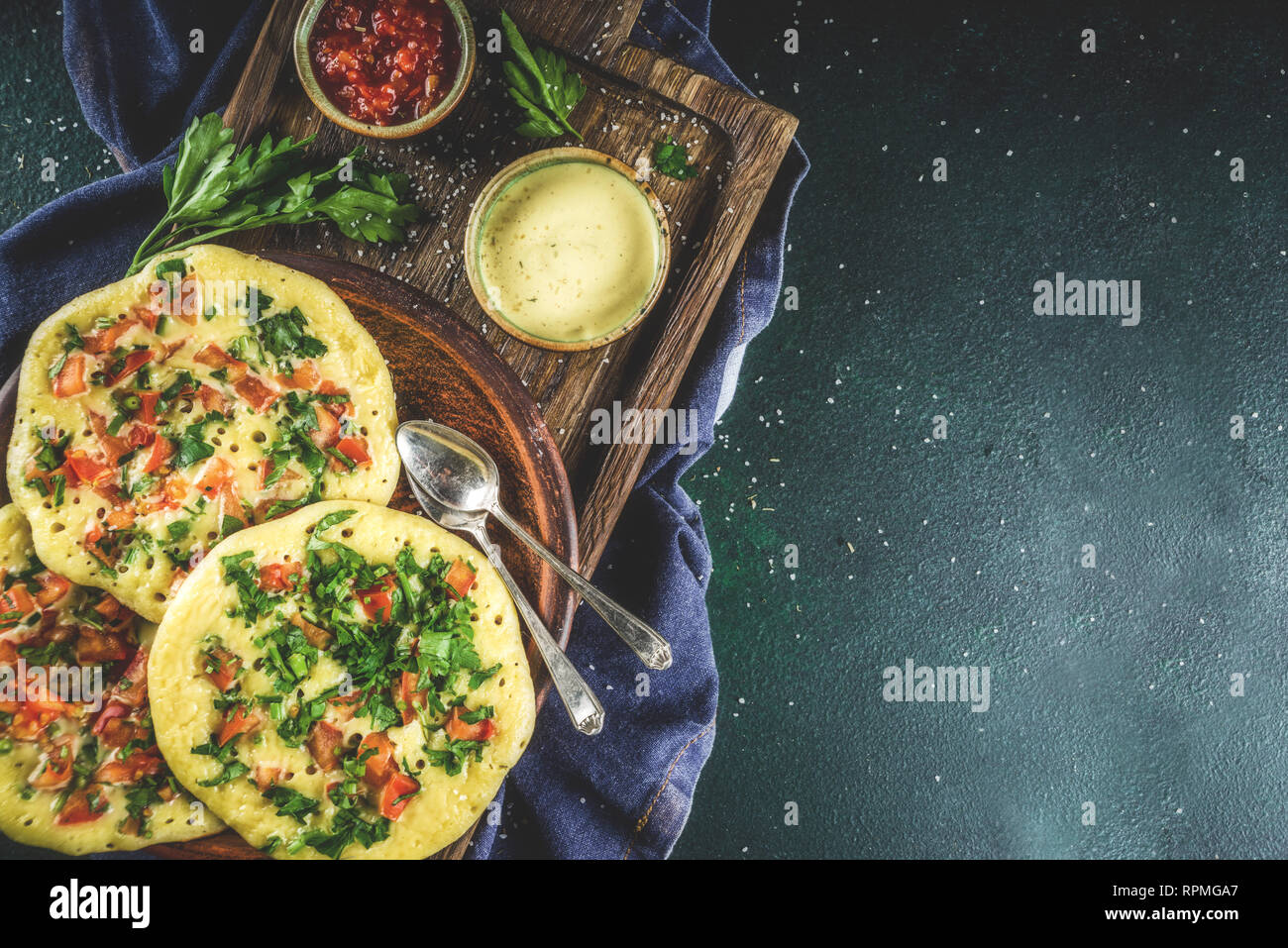 Traditionelles indisches Essen Rezepte, Hafer oder Uttapam Grieß Pfannkuchen  mit frischem Gemüse und Kräutern, dunkelblauen Hintergrund Kopie Raum,  Ansicht von oben Stockfotografie - Alamy