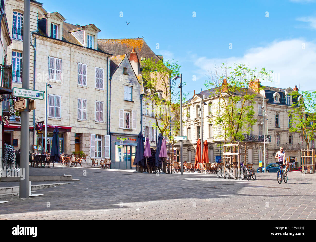 Saumur, Frankreich - 22 April, 2018: Ein Mann auf einem Fahrrad an der Eglise St Pierre Square in Einzelhaft, im Zentrum einer kleinen Stadt Saumur auf einem warmen Frühling morni Stockfoto Saumur, Frankreich - 22 April, 2018: Ein Mann auf einem Fahrrad an der Eglise St Pierre Square in Einzelhaft, im Zentrum einer kleinen Stadt Saumur auf einem warmen Frühling morni Stockfoto