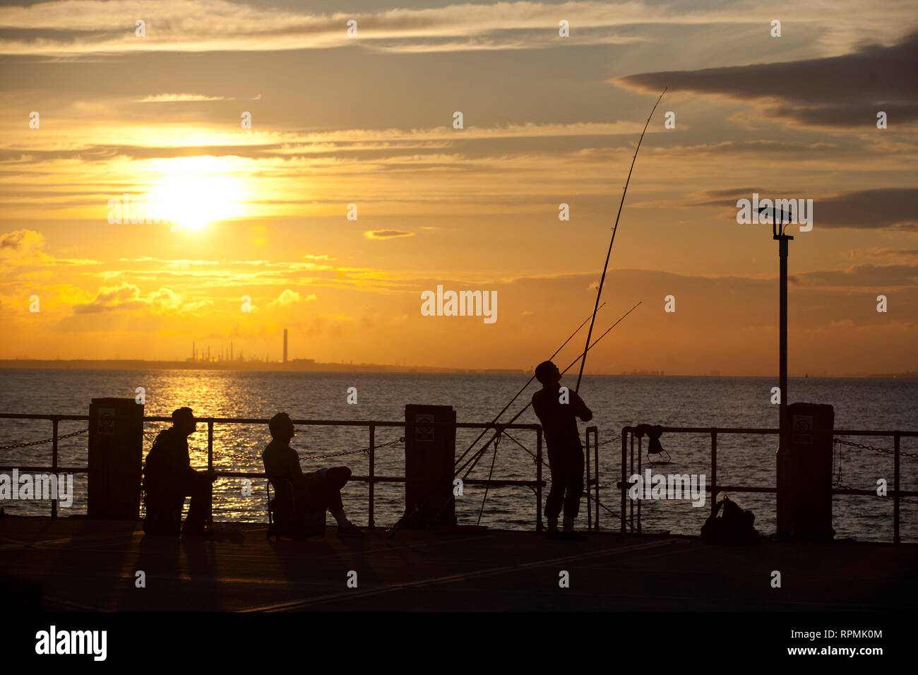 Männer Meer angeln am Ende von Ryde Pier bei Sonnenuntergang. Den Solent, UK, England, Isle of Wight, Ryde Stockfoto