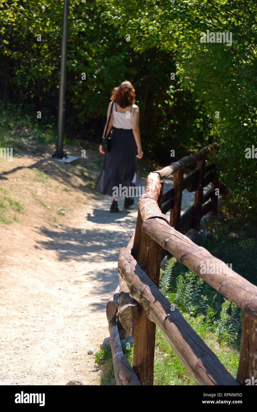 Junge Frau allein zu Fuß auf einem Wald Stockfoto