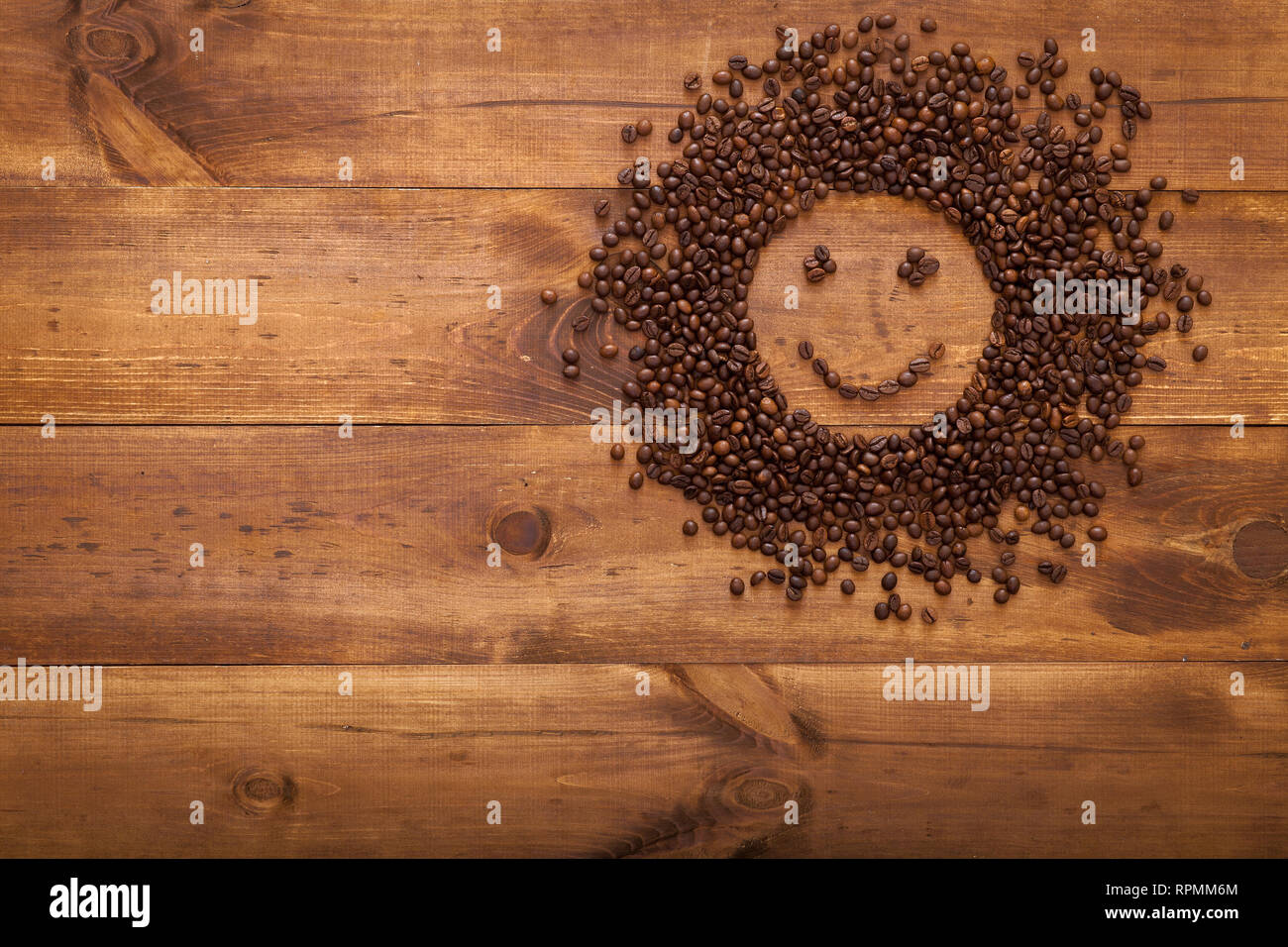 Schwarzen Kaffee Bohnen Samen in Sun Form auf braune Holztisch als morgen Energiekonzept, dunkle cofee geröstete Körner Aroma Aroma Cafe, natürliche Coffe Shop b Stockfoto