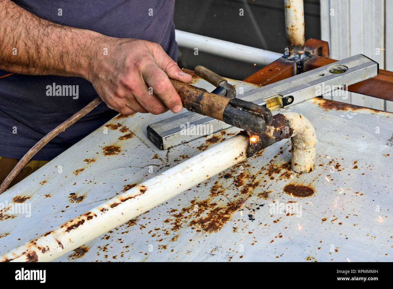 Der Master arbeitet auf Schweißen das Bügeleisen das Geländer Zaun zu reparieren. Stockfoto