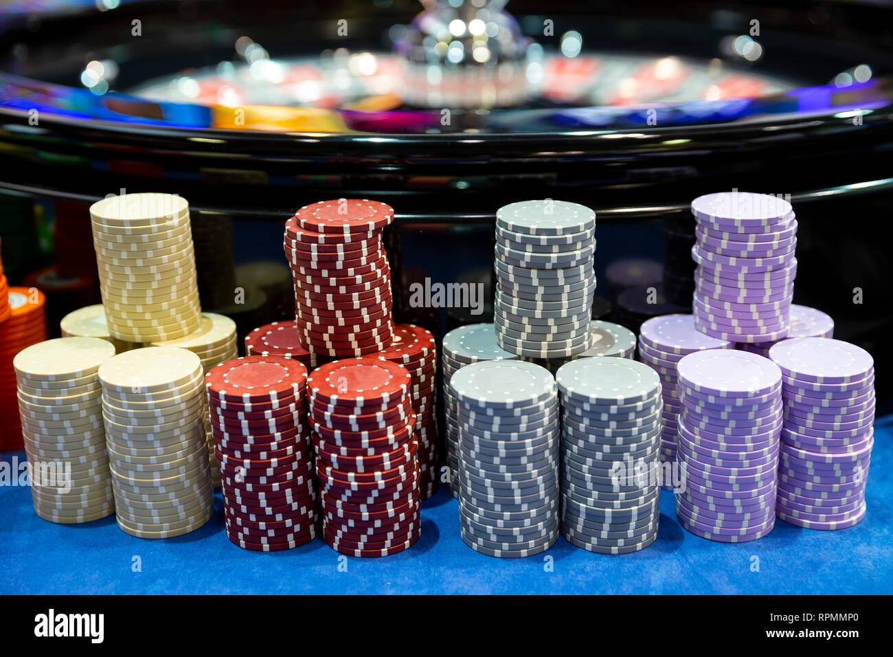 Bunte roulette Chips in ein Casino auf einem Spieltisch in der Nähe von Roulette Rad. Viele Chips mit verschiedenen Nominierung und Farben. Stockfoto