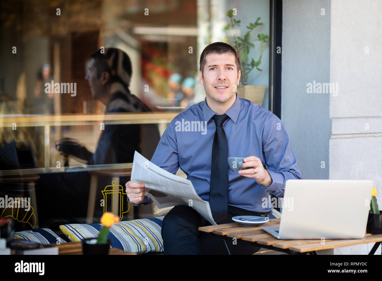 Geschäftsmann Entspannung im Cafe Terrasse am Morgen Kaffee trinken und Lesen finanzielle Zeitung Stockfoto