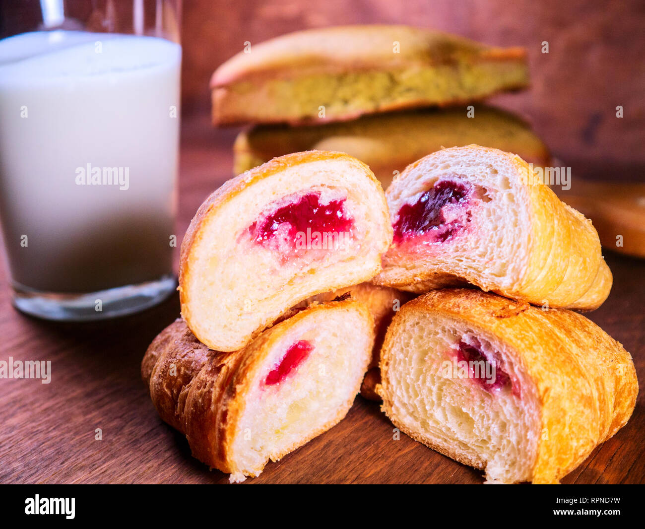 Frisches croissant Kirsche in ein Schnitt liegt auf der jeweils anderen, neben den Kuchen und Milch Stockfoto