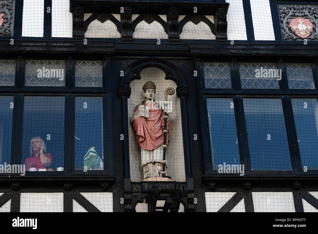 Eine Frau in einem Tudor Revival Gebäude in Exeter, UK. Stockfoto