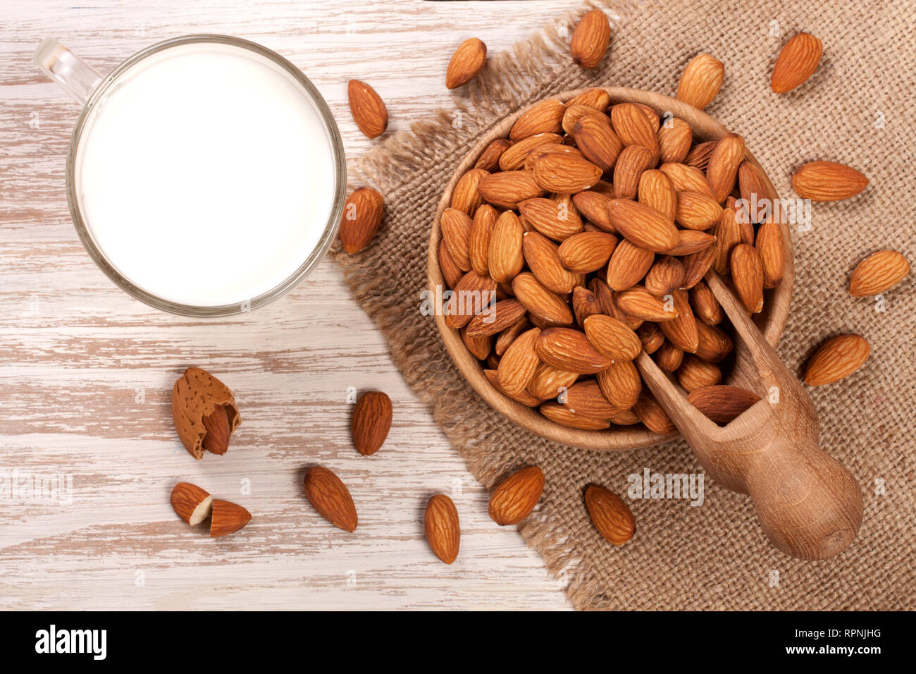 Mandel Milch in ein Glas und Mandeln in einer Schüssel auf hellen Hintergrund. Ansicht von oben Stockfoto