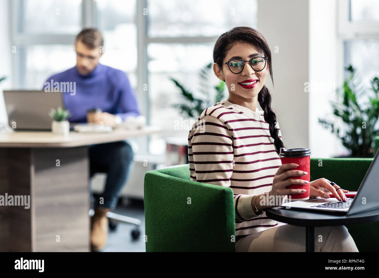 Hübsche brünette Arbeiten im Büro mit Vergnügen Stockfoto