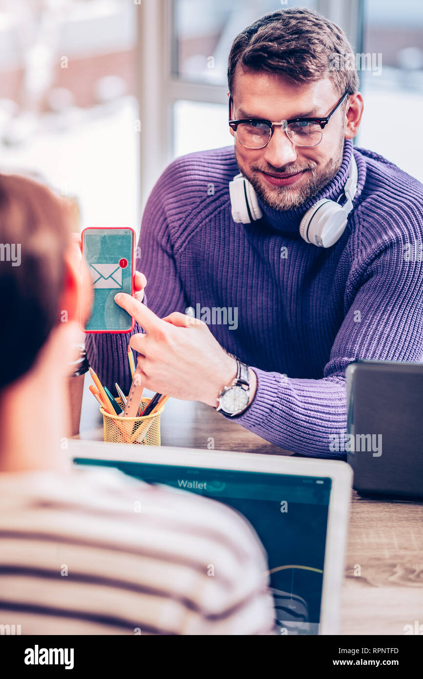 Rätselhafte brunette männliche Person an Mitarbeiter suchen Stockfoto