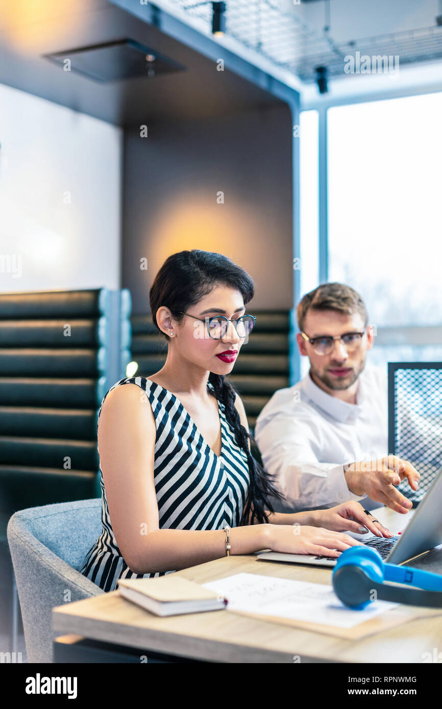 Aufmerksame junge büroangestellte eingeben Nachricht an Chef Stockfoto