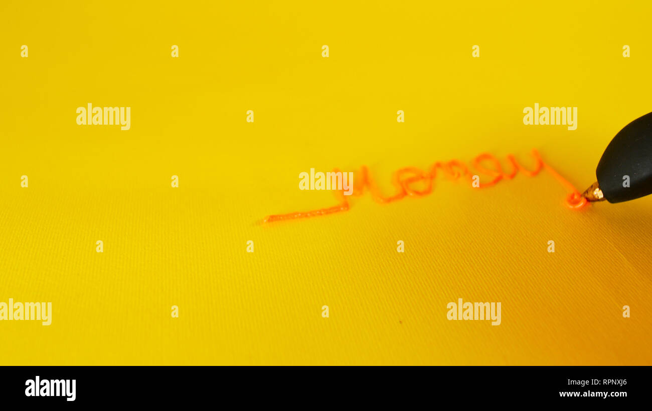 Die Hand eines Mannes schreibt das Geld auf gelbem Hintergrund mit 3d Drucker pen, Filmmaterial ideal für Themen wie Innovation und Technologie geschrieben Stockfoto