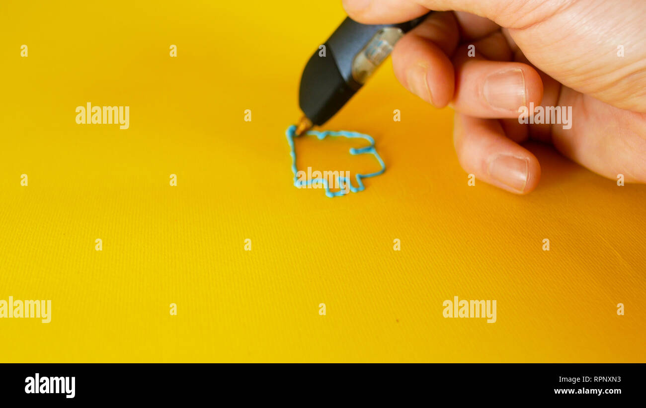Einen Mann zieht mit einem 3D-Drucker pen Der bitcoin Symbol auf gelbem Hintergrund, Filmmaterial ideal für Themen wie Innovation, Technologie und Häuser Stockfoto