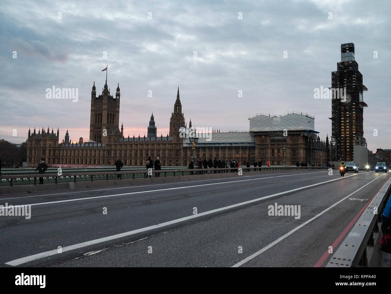 Ein Blick auf die Häuser des Parlaments mit Gerüst auf in der Dämmerung mit einem leeren Westminster Bridge nur Fern verkehr und Fußgänger angezeigt. Stockfoto