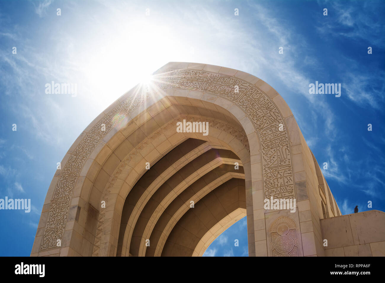 Detail eines Bogens der Muscat Grand Moschee mit Sonne im Gegenlicht (Oman) Stockfoto