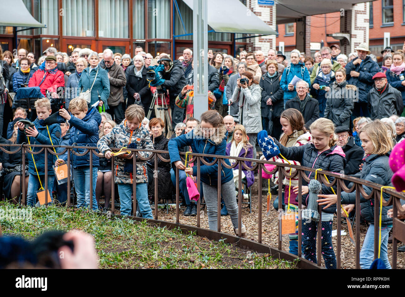 Nijmegen, Gelderland, Niederlande. 22 Feb, 2019. Eine Gruppe von Kindern aus der Montessori Schule gesehen, Hüte und Hinweise rund um das Denkmal während der gedenkfeier. Die Bombardierung von Nijmegen war eine ungeplante Bombenanschlag von amerikanischen Flugzeugen, die auf der Stadt Nijmegen in den Niederlanden am 22. Februar 1944. Während dieser Alliierten fehler Bombardierung, fast 800 Menschen getötet und einen großen Teil des Stadtzentrum von Nijmegen wurde zerstört. Jeder 22. Februar eine offizielle Gedenkfeier findet auf dem Raadhuishof, der Ort, an dem der Montessori Schule befand, wo 24 chi Stockfoto