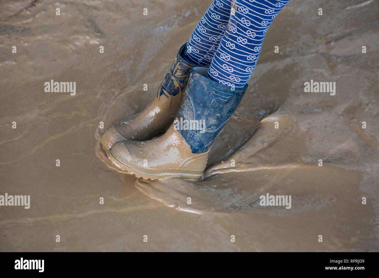 Muddy Gummistiefel in einer schlammigen Pfütze, Sussex, UK Stockfoto
