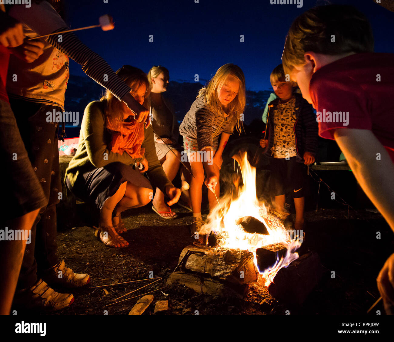 Kinder toasten Marshmallows über einem Lagerfeuer auf einem Campingplatz in Sussex, UK Stockfoto