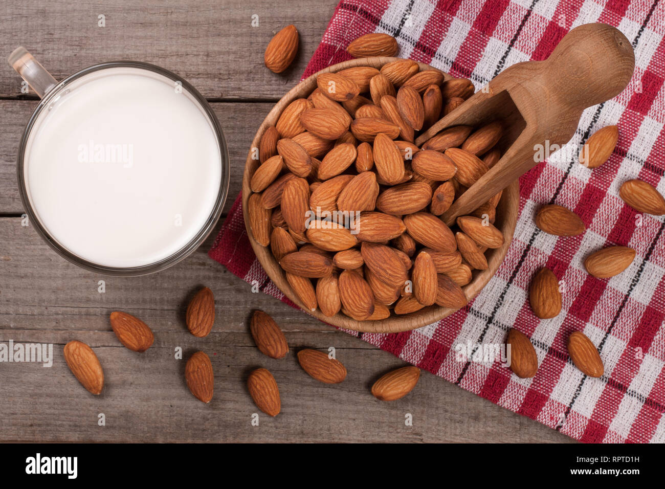 Mandel Milch in ein Glas und Mandeln in einer Schüssel auf alten hölzernen Hintergrund. Ansicht von oben Stockfoto